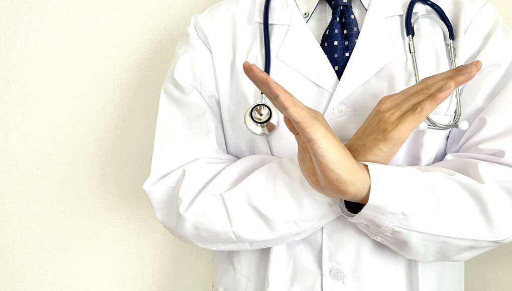 医者が手でバツを作り医学的根拠はないことを示す様子