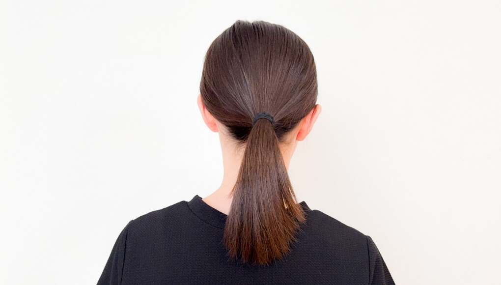 髪を結ぶ女性の後頭部