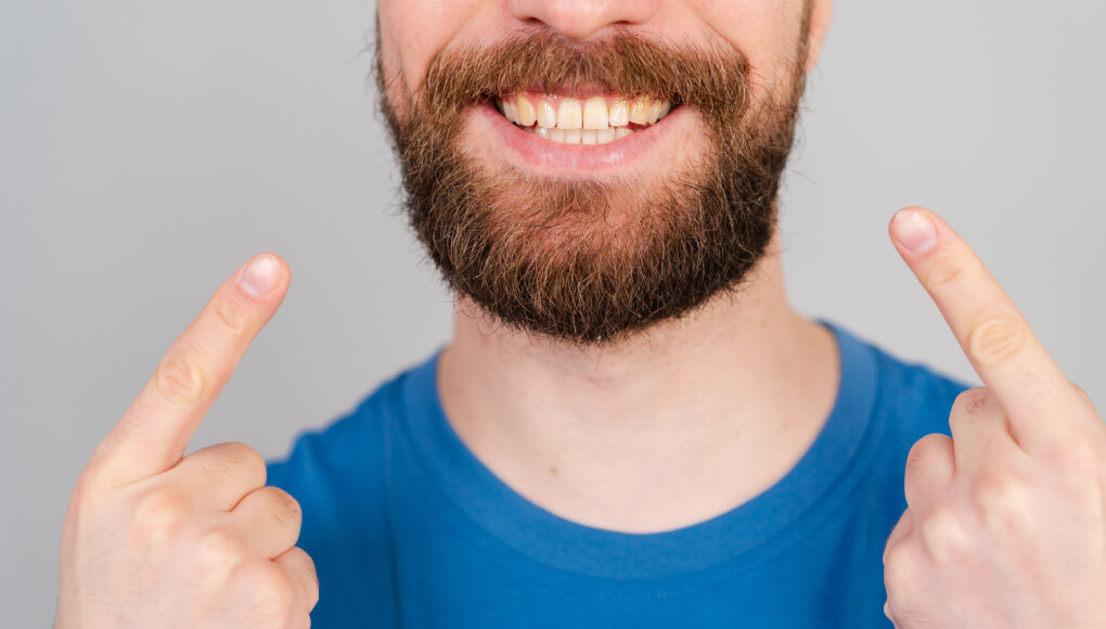 ひげを指さす男性の口元